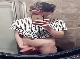Twink shows off his long cock in the mirror